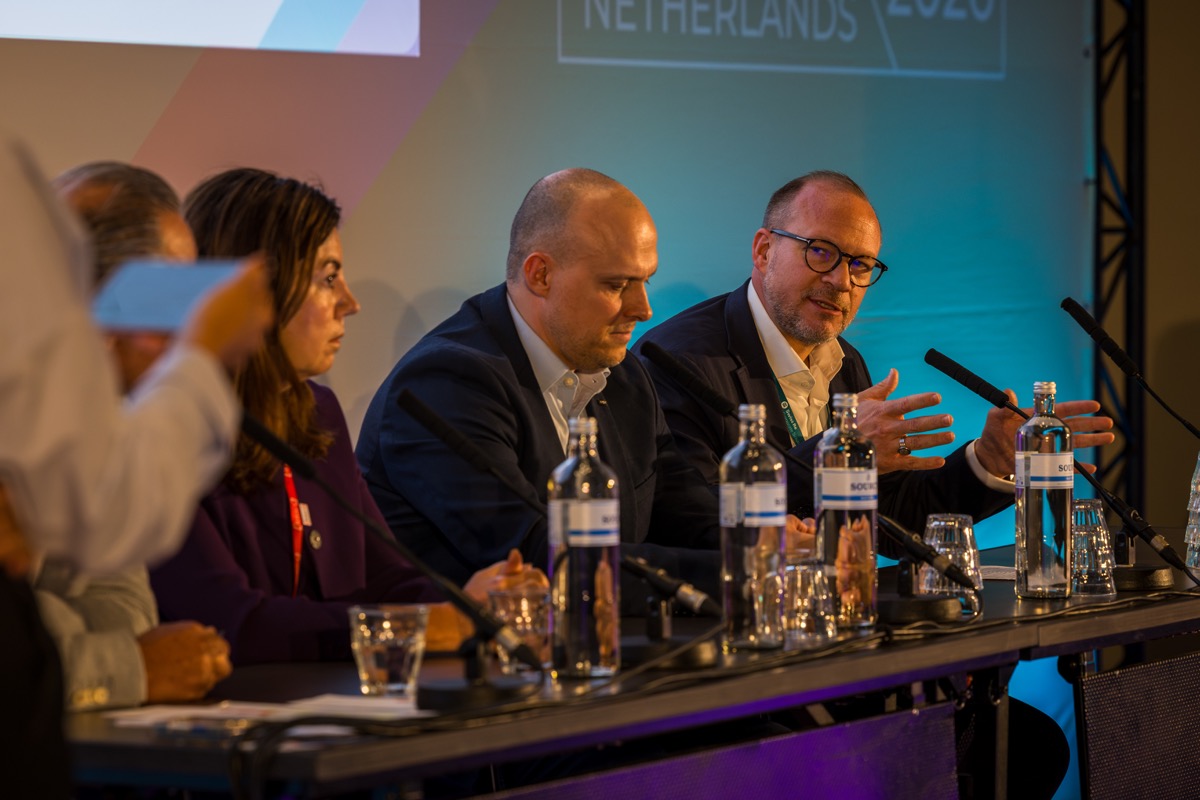 Panellists reacting during a conference panel — moment captured by event photographer