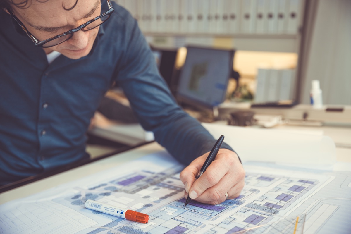 Architect working on building plans at office