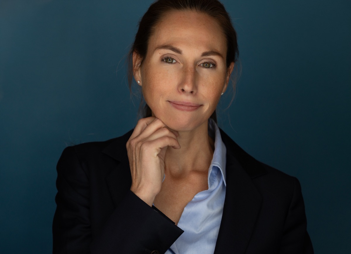 Zakelijk studio-portret vrouwelijke professional in navy colbert — portretfotograaf Den Haag