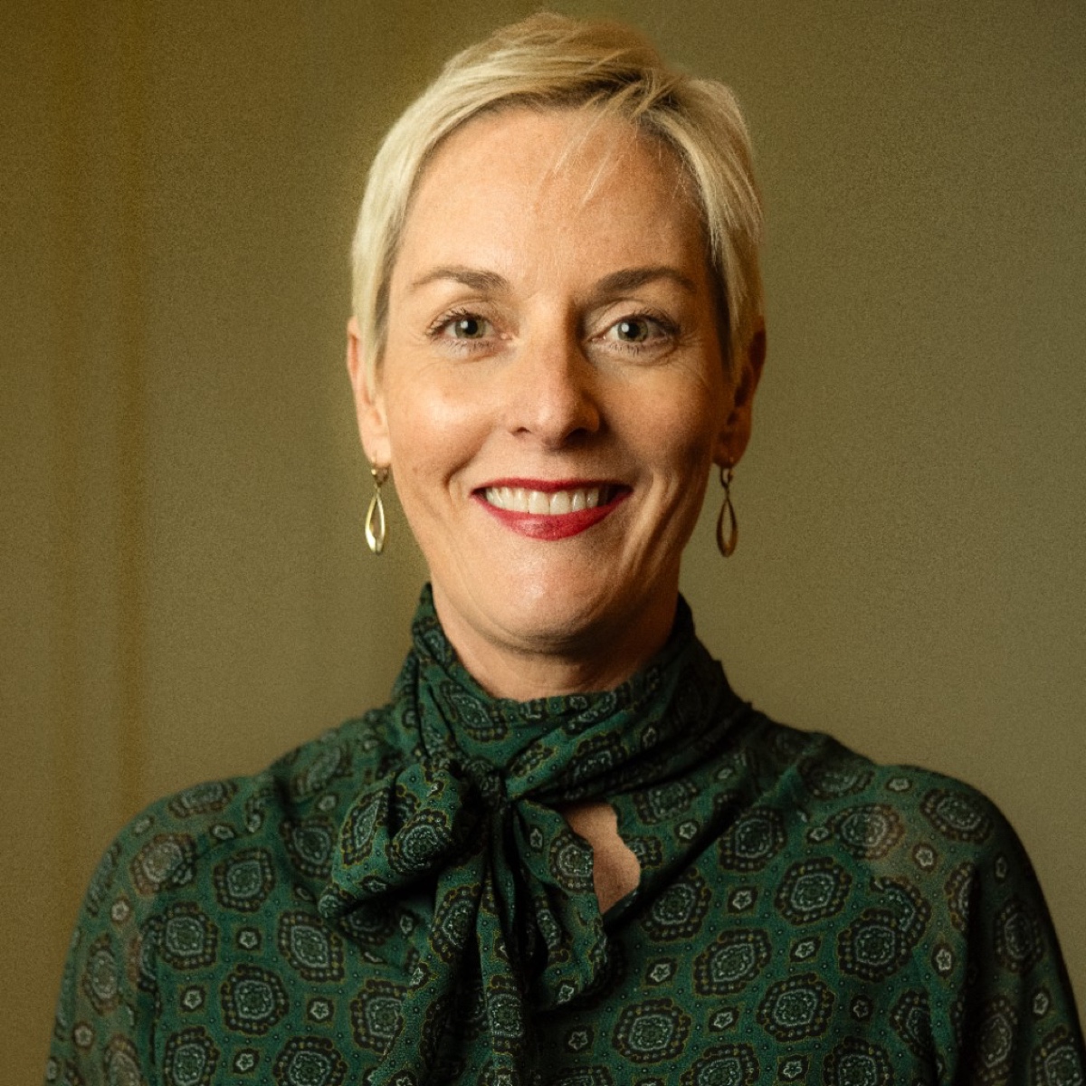 Zakelijk portret vrouw met groene achtergrond — LinkedIn profielfoto Den Haag
