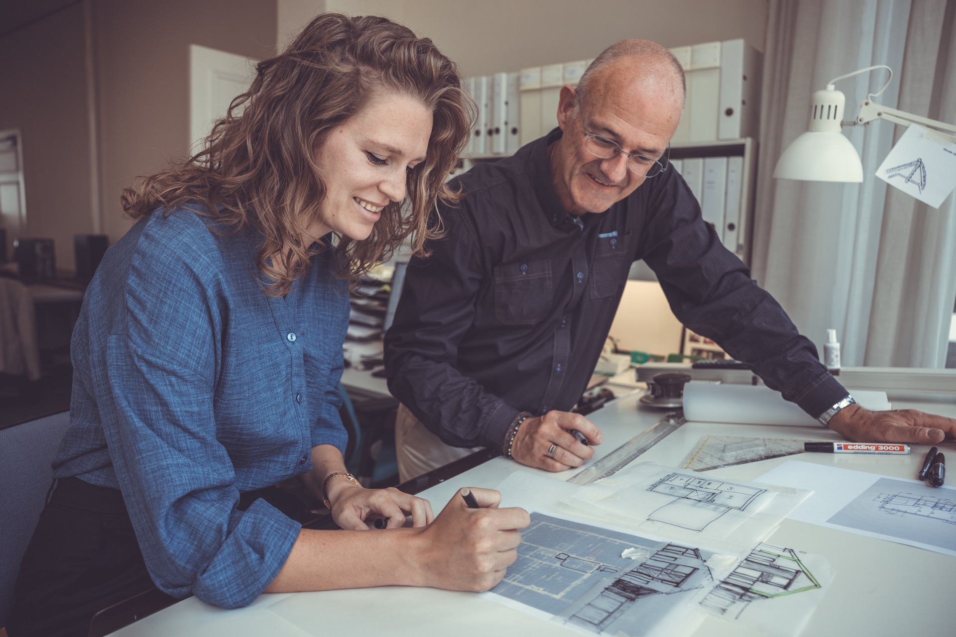 Architecten werken samen aan bouwtekeningen in studio — bedrijfsfotograaf Den Haag
