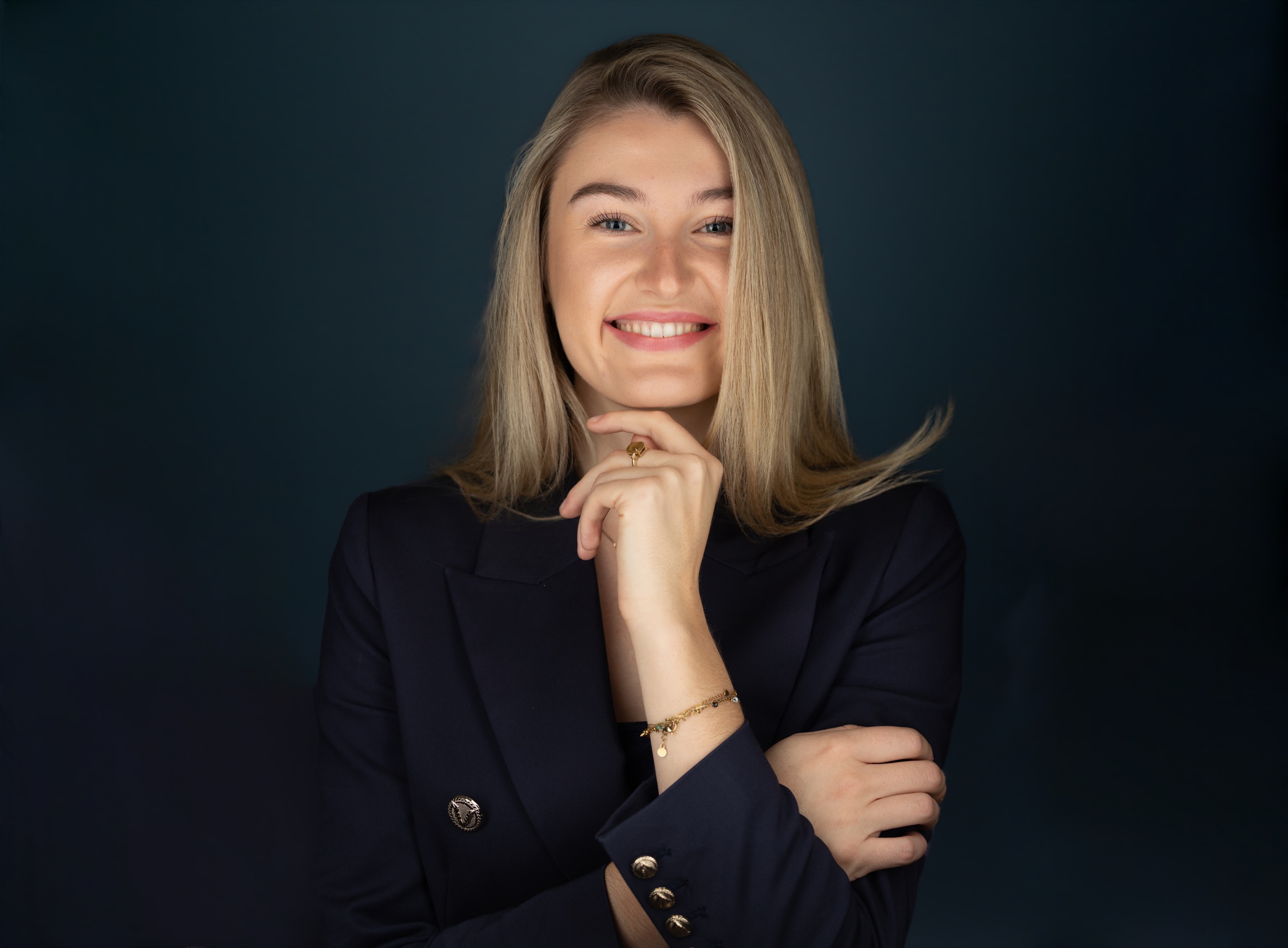 Zakelijk studio-portret vrouwelijke professional met blonde haren in navy colbert — portretfotograaf Den Haag