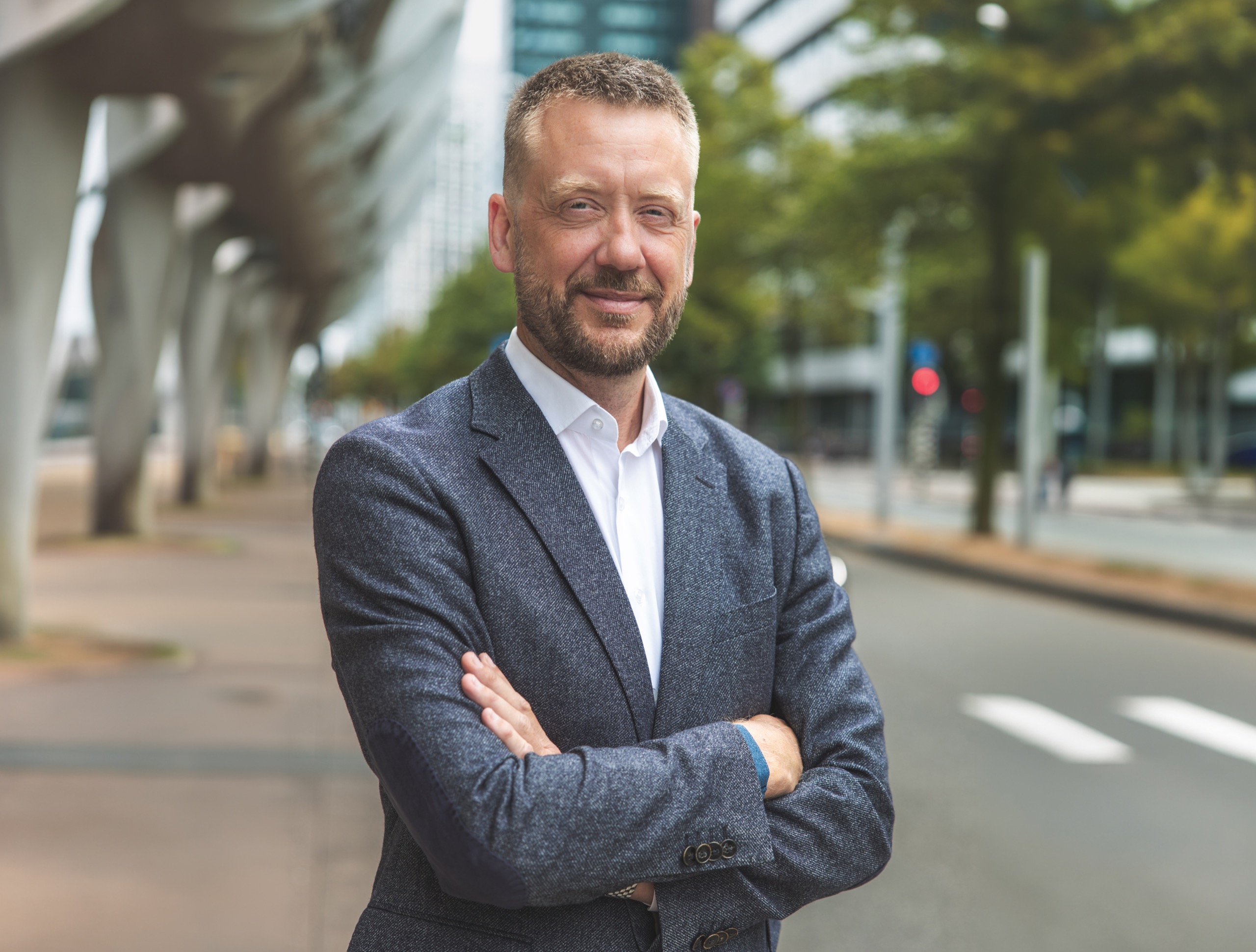 CEO-portret buiten — gekruiste armen, grijs colbert — portretfotograaf Den Haag